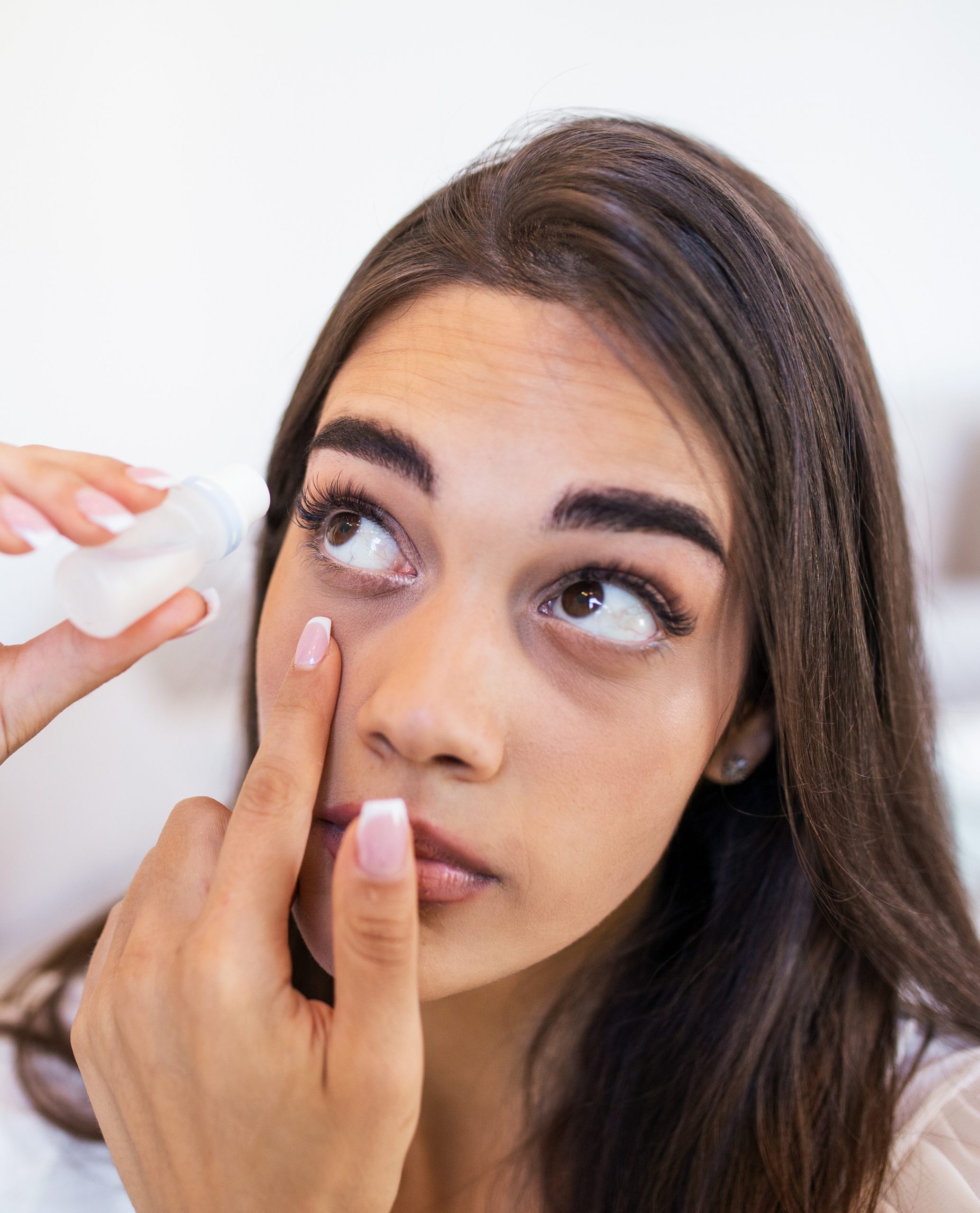 Female dropping eye lubricant to treat dry eye or allergy